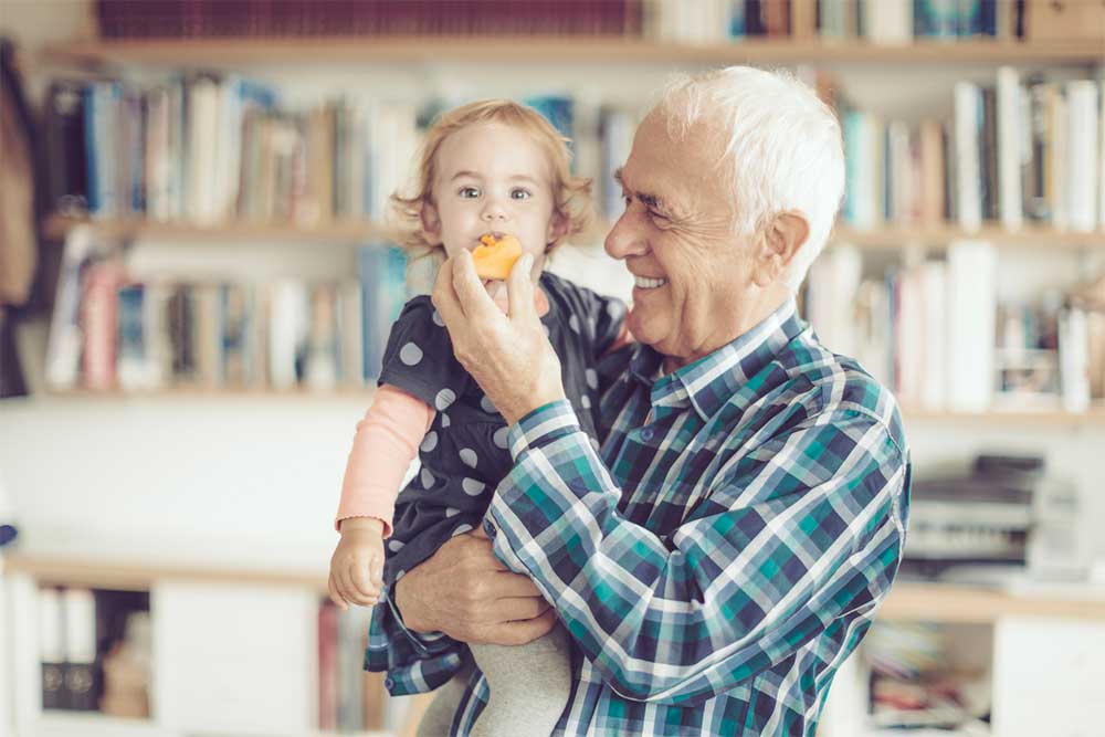 grandpa feeding granddaughter fruit