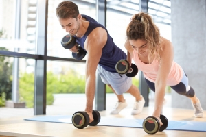 man and woman lifting weights