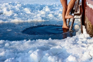 man swimming in ice hole
