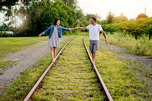 couple balancing on railroad tracks