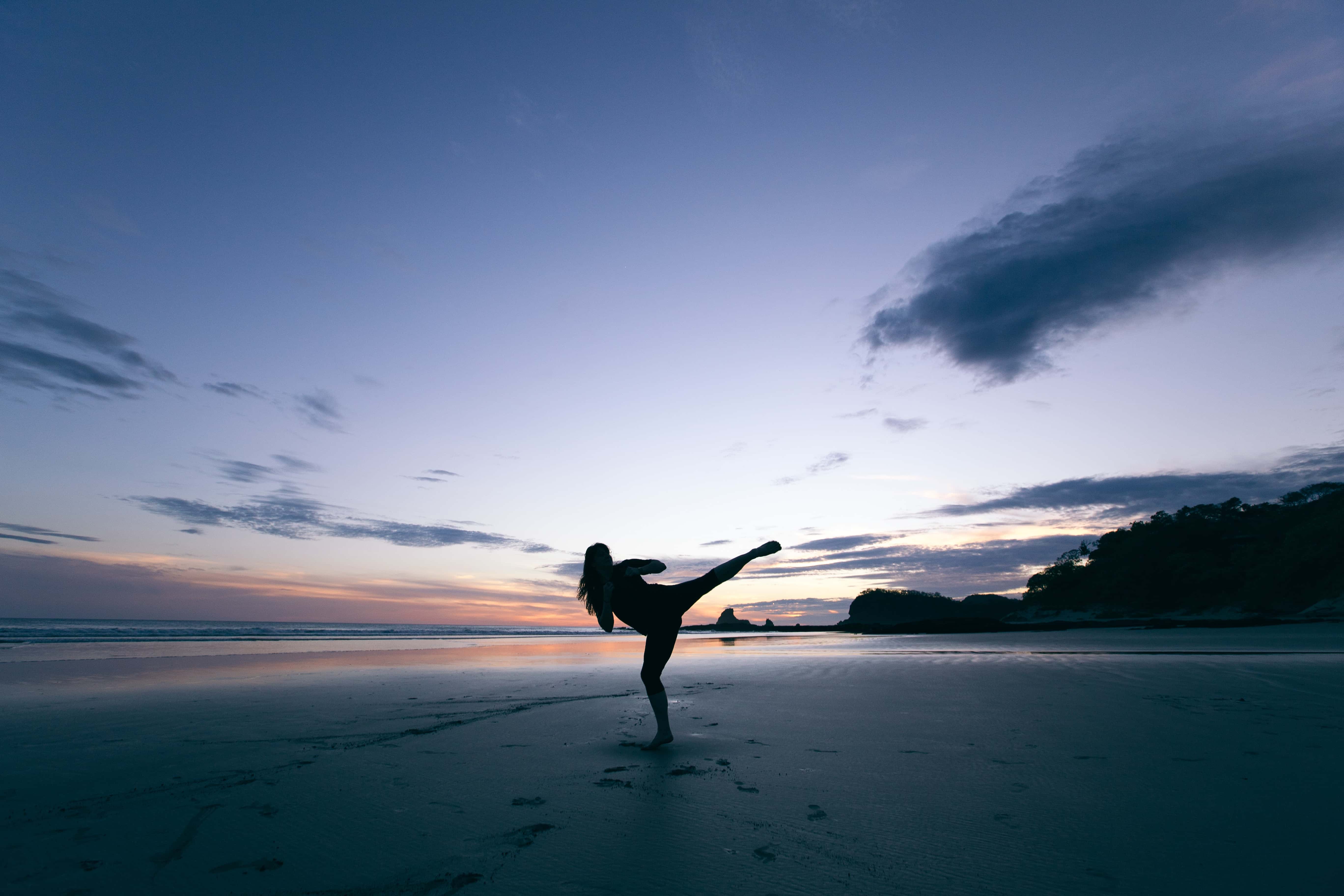Woman Karate Kicking on Beach