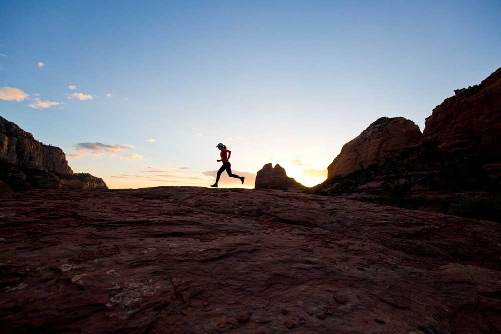 Female athlete running through the desert