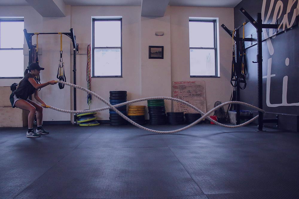 woman training with ropes in gym