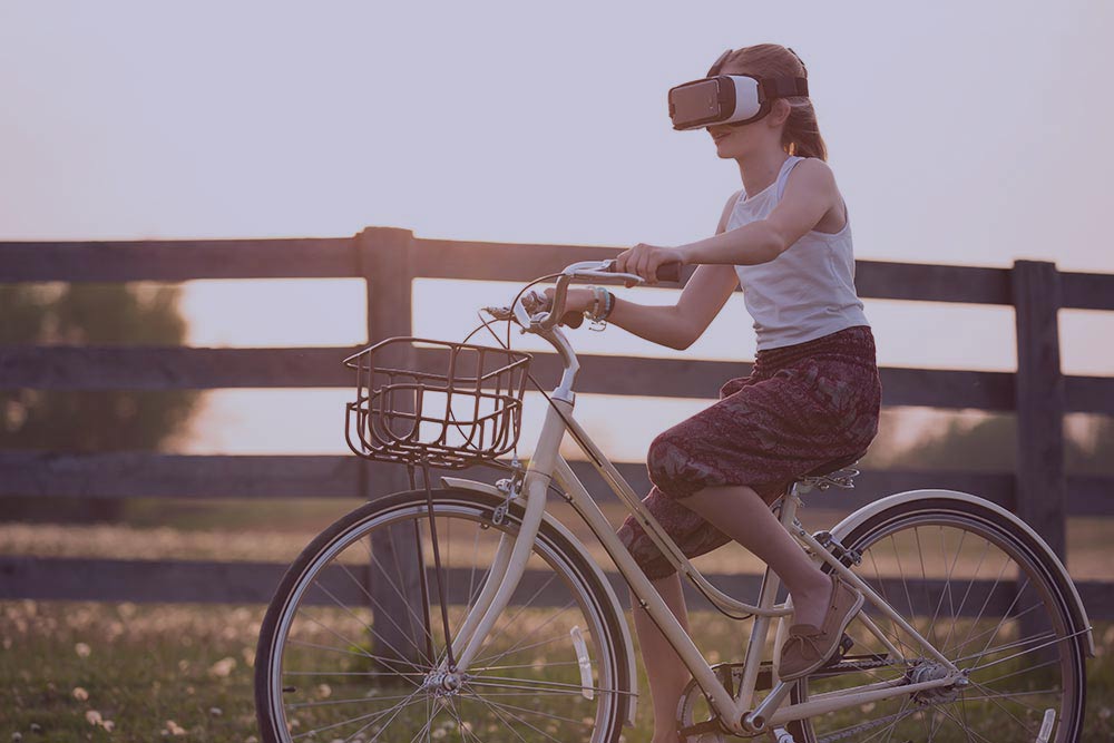 Girl riding a bike wearing virtual reality goggles