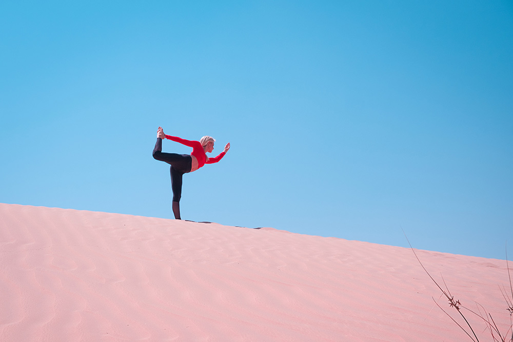Woman balancing on sand dune