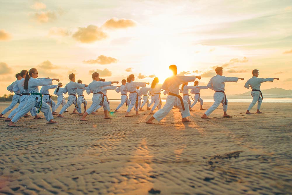 group doing tai chi on a beach