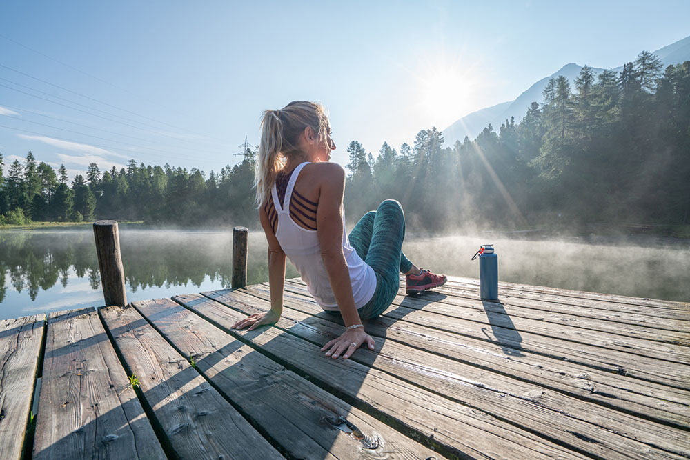 Young female athlete jogger resting by a lake